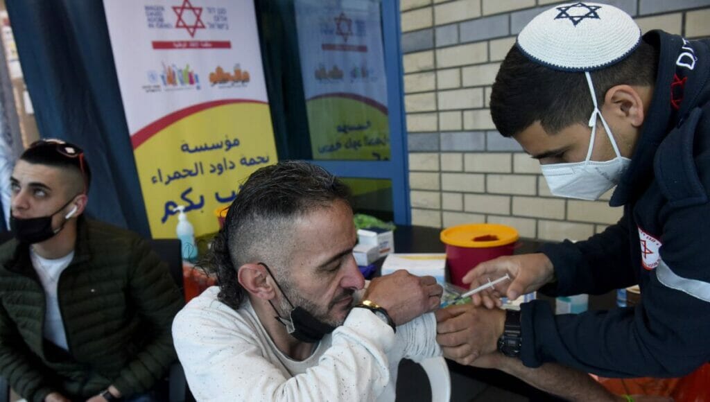 Mitarbeiter des israelischen "Roten Davidstern" impft einen Palästinenser am Qalandiya-Grenzübergang