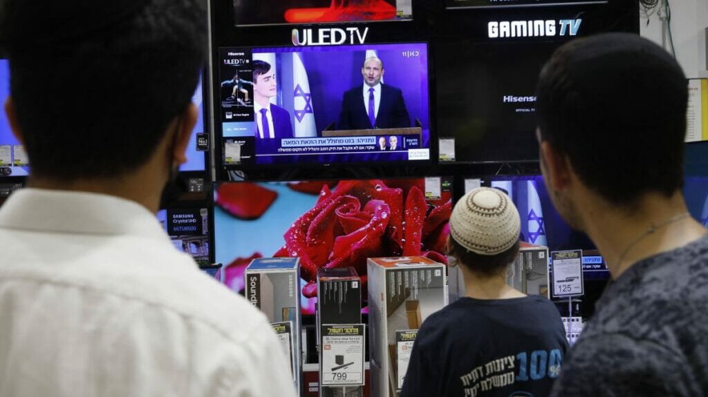 Israelis sehen die Pressekonferenz auf der Naftali Bennett seine Einigung mit Yair Lapid bekannt gibt