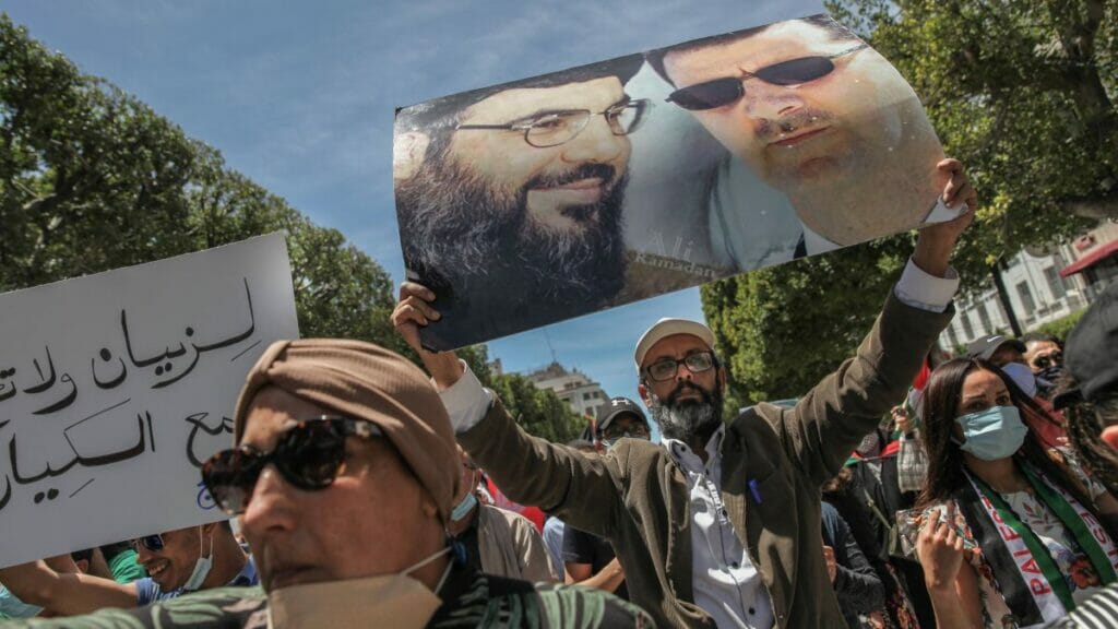 Demonstrant mit Palakt von Hisbollah-Führer Nasrallah und Syriens Diktator Assad