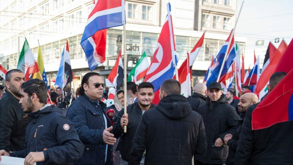 Assad-anhänger in Deutschland demonstrieren mit Iran- und Nordkorea-Flaggen