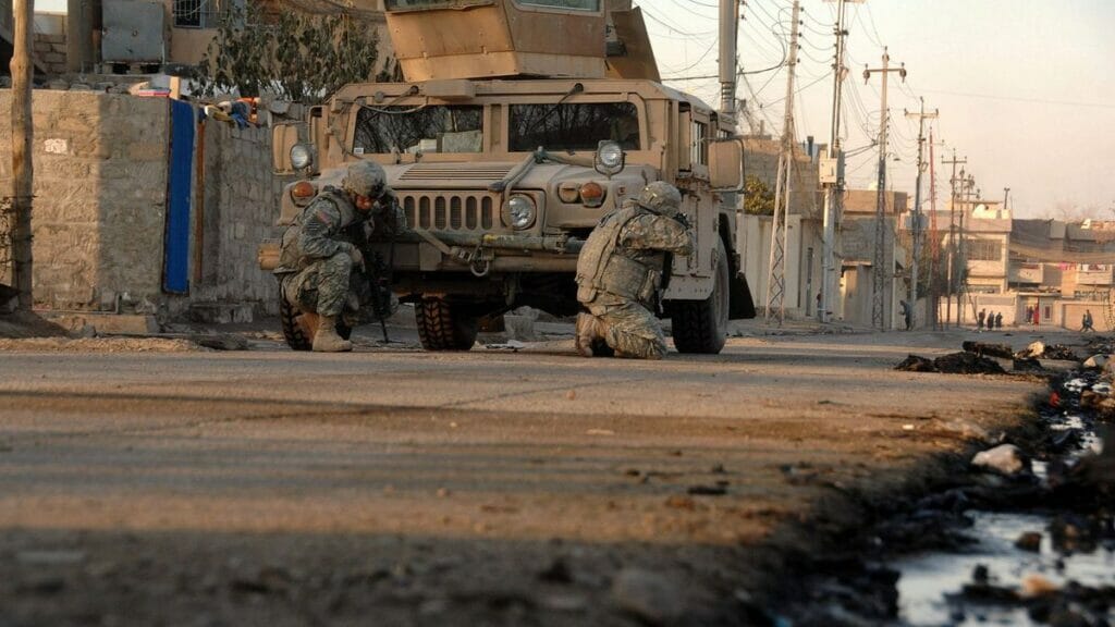 US-Soldaten in der irakischen Stadt Mosul gehen hinter ihrem Fahrzeug in Deckung