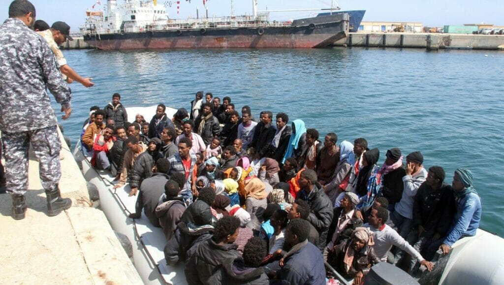 Mitglieder der libyschen Küstenwachen mit Flüchtlingen aus Subsahara-Afrika
