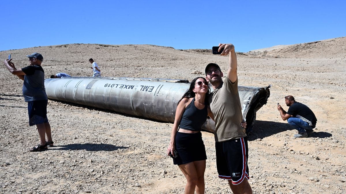 Israelis machen Selfies mit einer von der Luftabwehr abgeschossenen iranischen Rakete im Negev