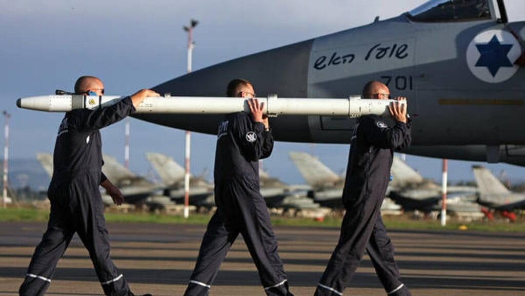 Soldaten der israelischen Luftwaffen beladen ein Kampfflugzeug mit Raketen