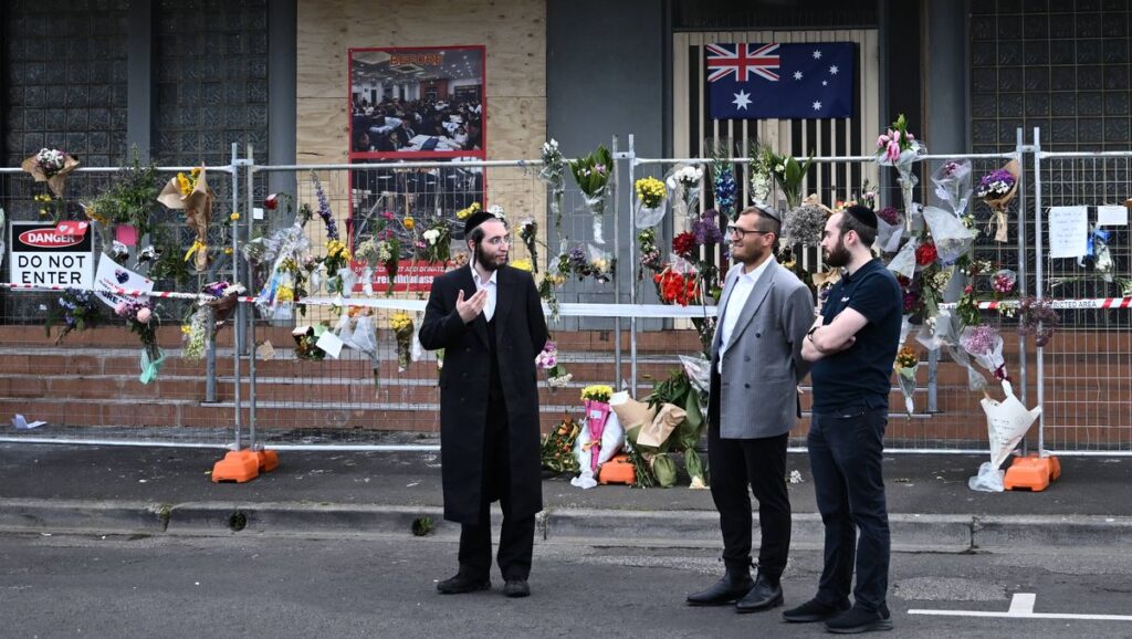 Rabbi Gabi Kaltmann (mi.) vor der bei einem Brandanschlag ausgebrannten Adass-Israel-Synagoge in Melbourne
