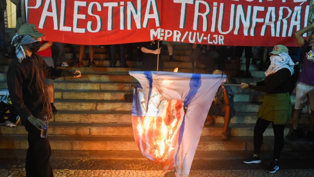 Teilnehmer einer antisemitischen Demonstration im brasilianischen Rio de Janeiro verbrennen eine Israelfahne