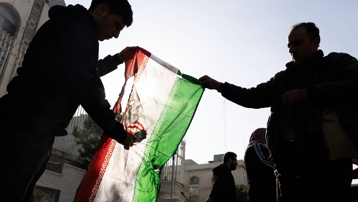 Zwei Syrer vor der iranischen Botschaft in Damaskus zünden die Flagge der Islamischen Republik an