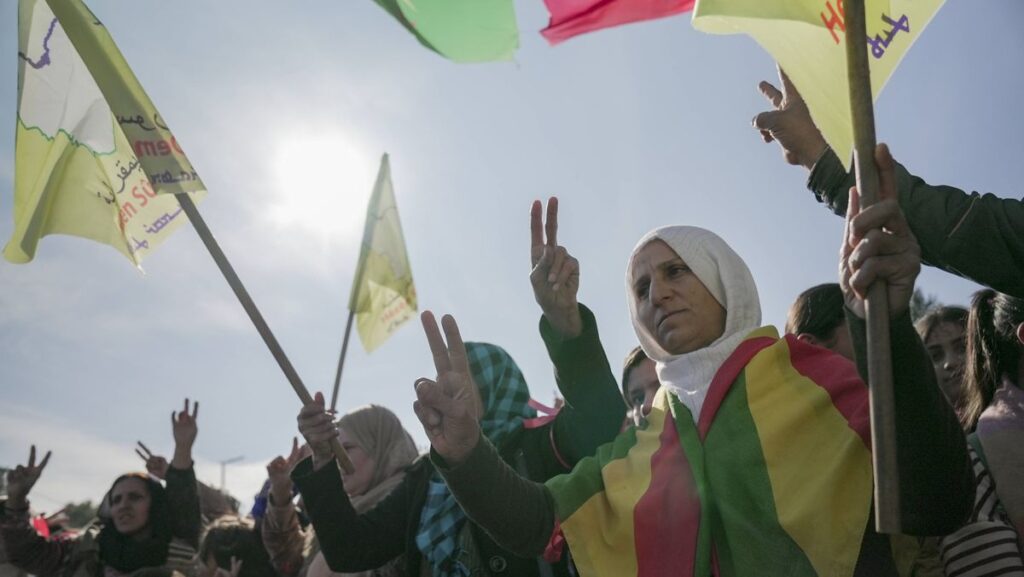 Präsident al-Sharaa und die Kruden: Frauen mit Flaggen der Demokratischen Kräfte Syriens (SDF)