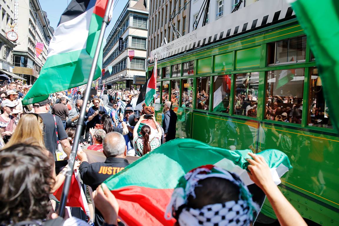 Wütende Demonstraten mit palästinensischen Flaggen bestürmen den Wagen mit der israelischen Delegation beim ESC in Basel. (© imago images/Manuel Stefan)