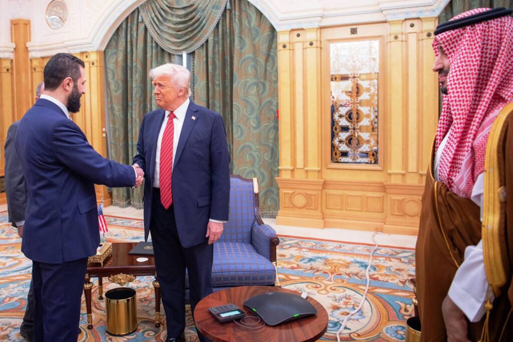 Handschlag zwischen Ahmed al-Sharaa und Donald Trump im Beisein von Mohammed bin Salman. (© imago images/UPI Photo)