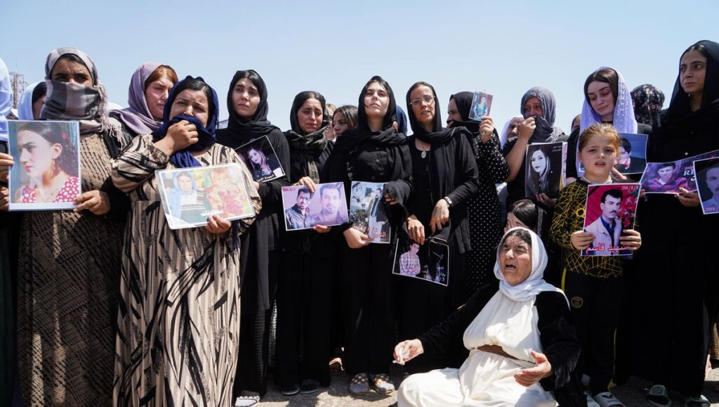 Jesidinnen im Irak mit Bildern ihrer immer noch vermissten Angehörigen