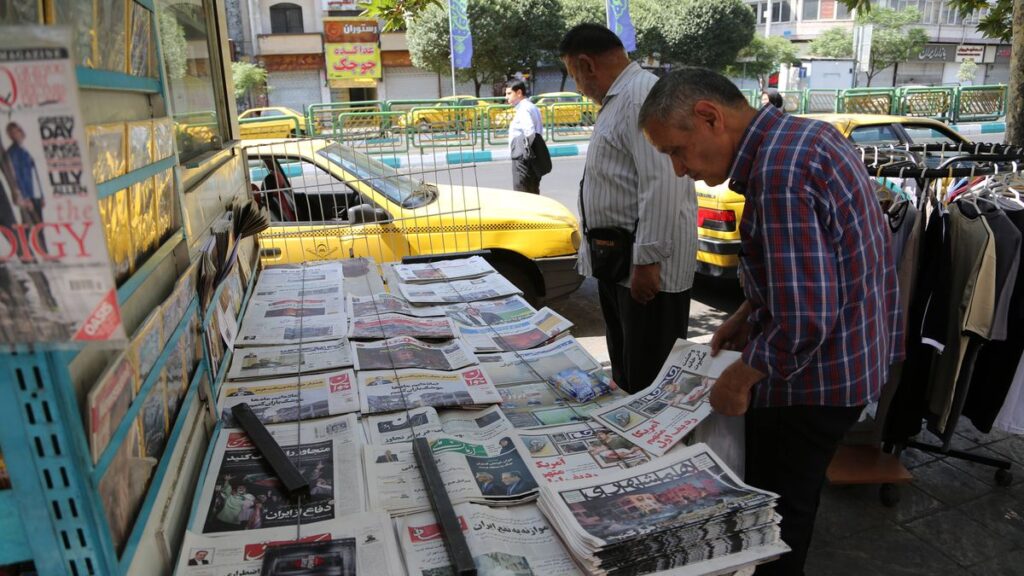 Zwei Iraner in Teheran betrachten die Schlagzeilen am Zeitungsstand