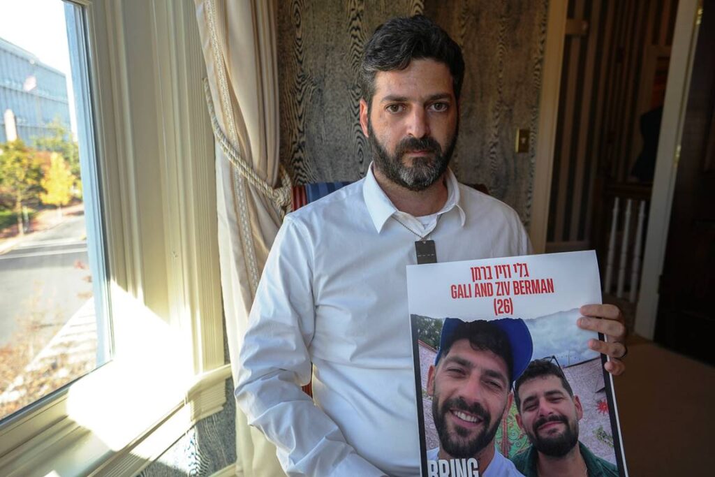 Liran Berman mit einem Plakat, auf dem seine beiden als Geiseln genommenen Brüder Gal und Ziv zu sehen sind. (© imago images/Imagn Images)