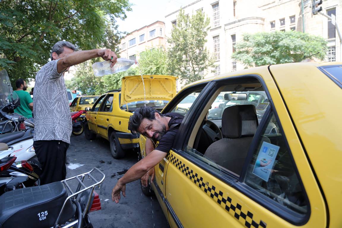 In der iranischen Hauptstadt versucht ein Taxifahrer, mit er Hitze fertigzuwerden. (© imago images/Xinhua)