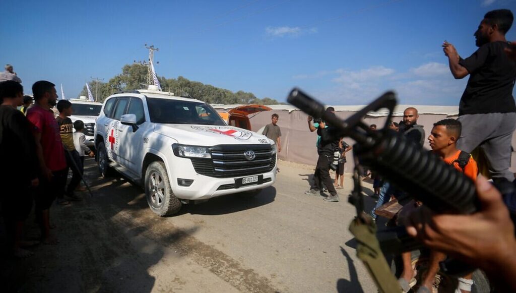 Hamas-Terroristen bei der Übergabe lebender Geiseln an des Rote Kreuz am 13. Oktober
