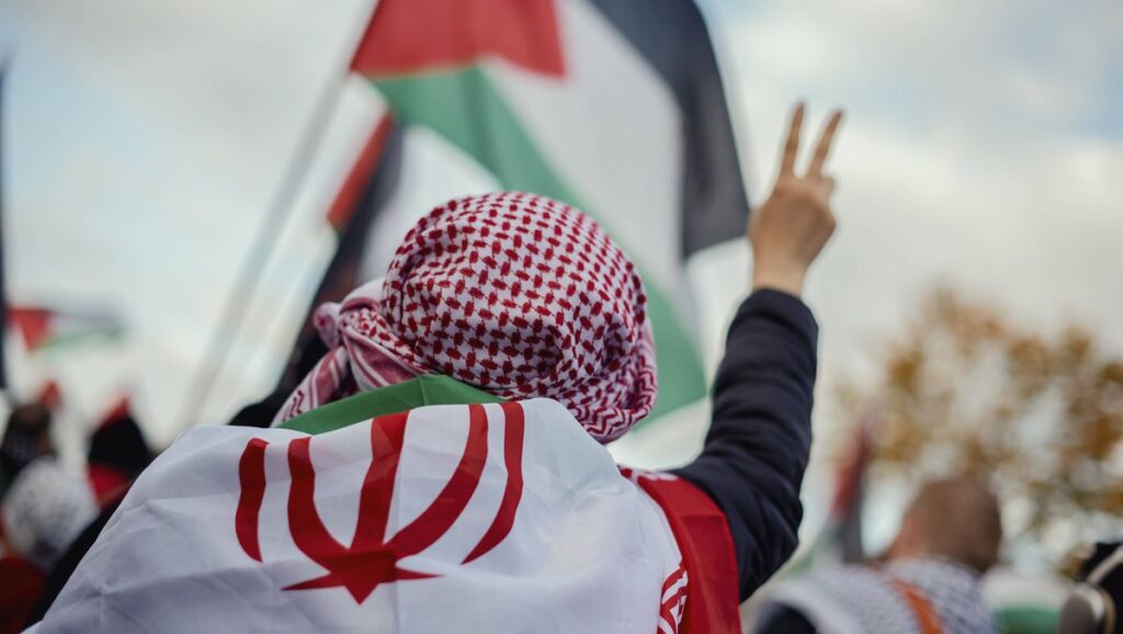 Demonstrant mit iranischer Flagge auf Antiisrael-Protest in Berlin