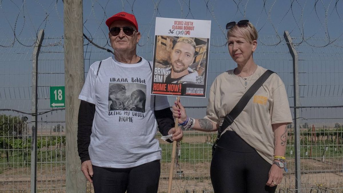 Verwandte von Elkana Bohbot mit Bild des Hamas-Gefangenen am Grenzzaun zu Gaza