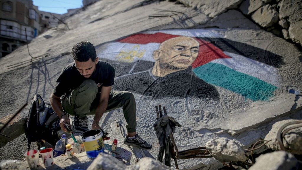 Obai Al-Karshali malt Porträt des ägyptischen Trainers Hossam Hassan auf Trümmer eines Hauses in Gaza